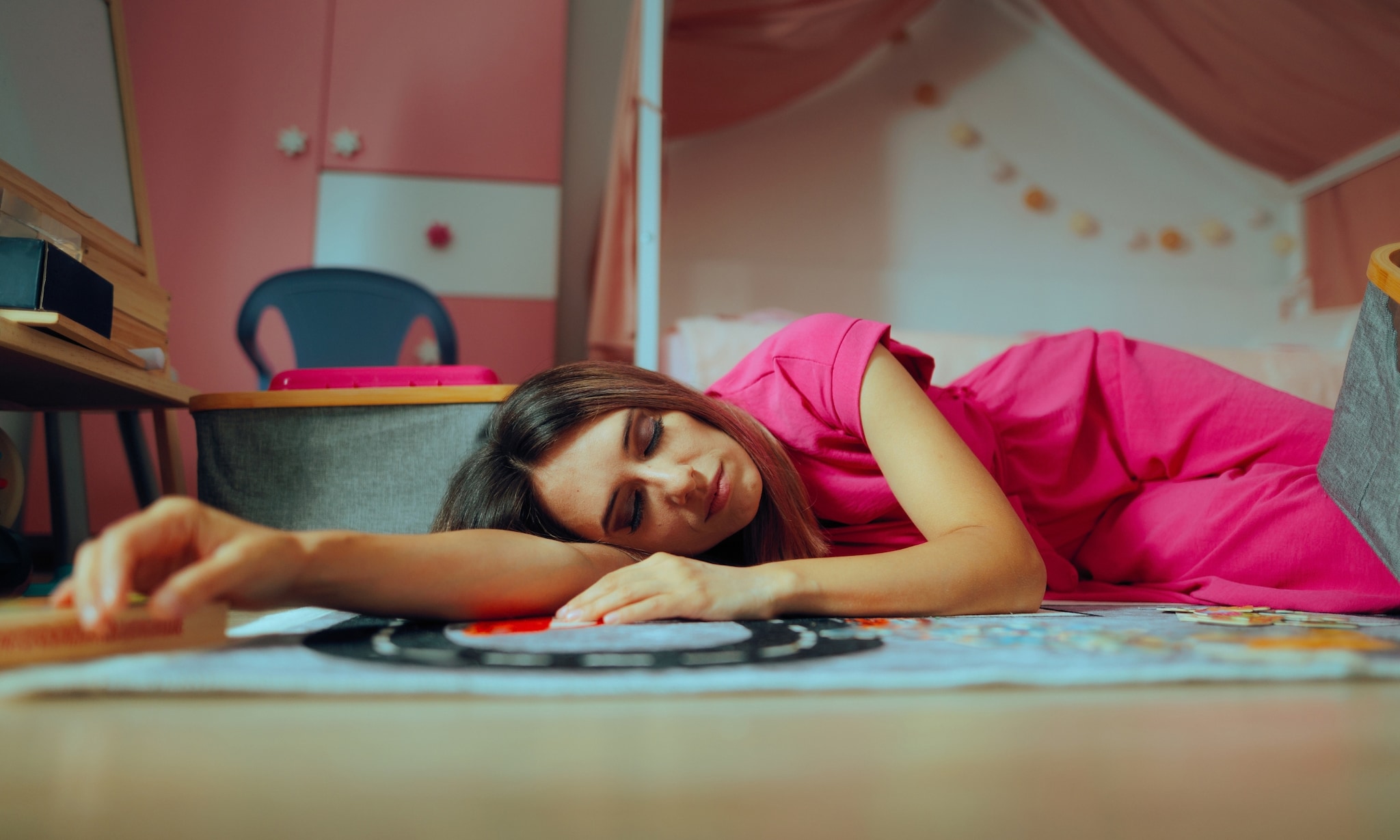 Moeder is in slaap gevallen op de vloer van een kinderkamer. Adobe Stock