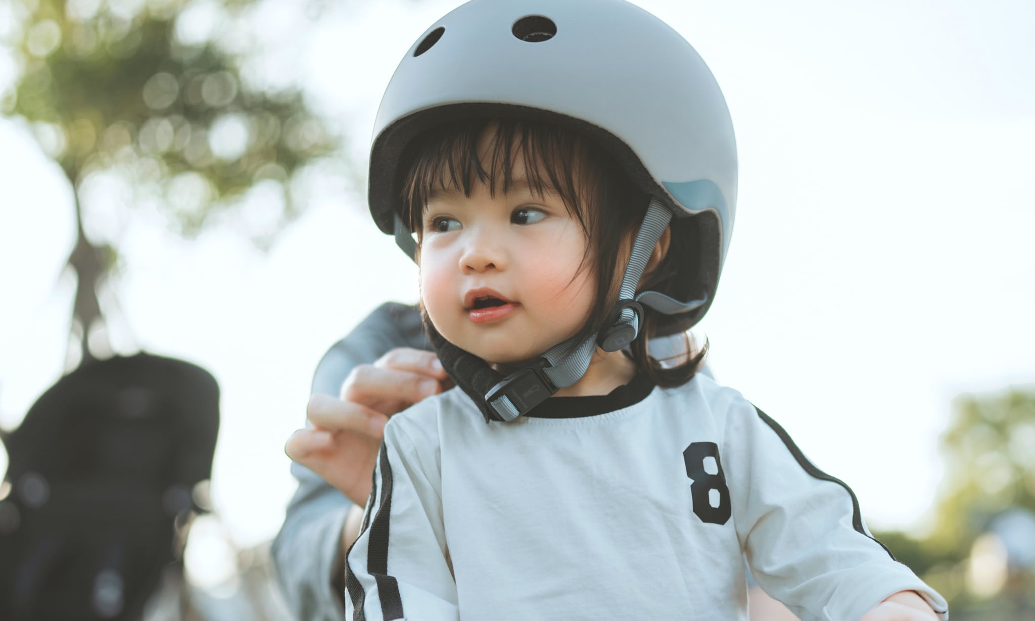 ouder helpt kind met helm om samen te gaan fiets op longtailbike, alternatief voor de bakfiets