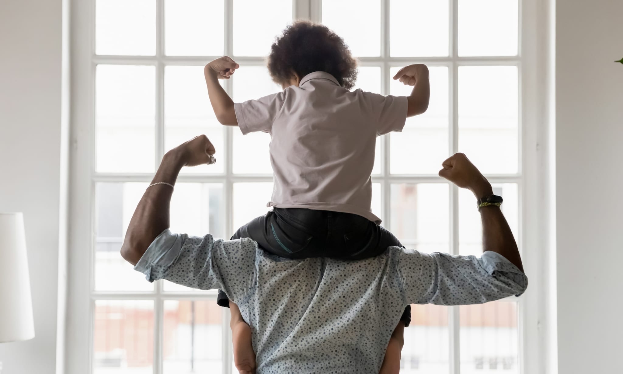 Vader en zoon op de rug gezien, laten hun spierballen zien.