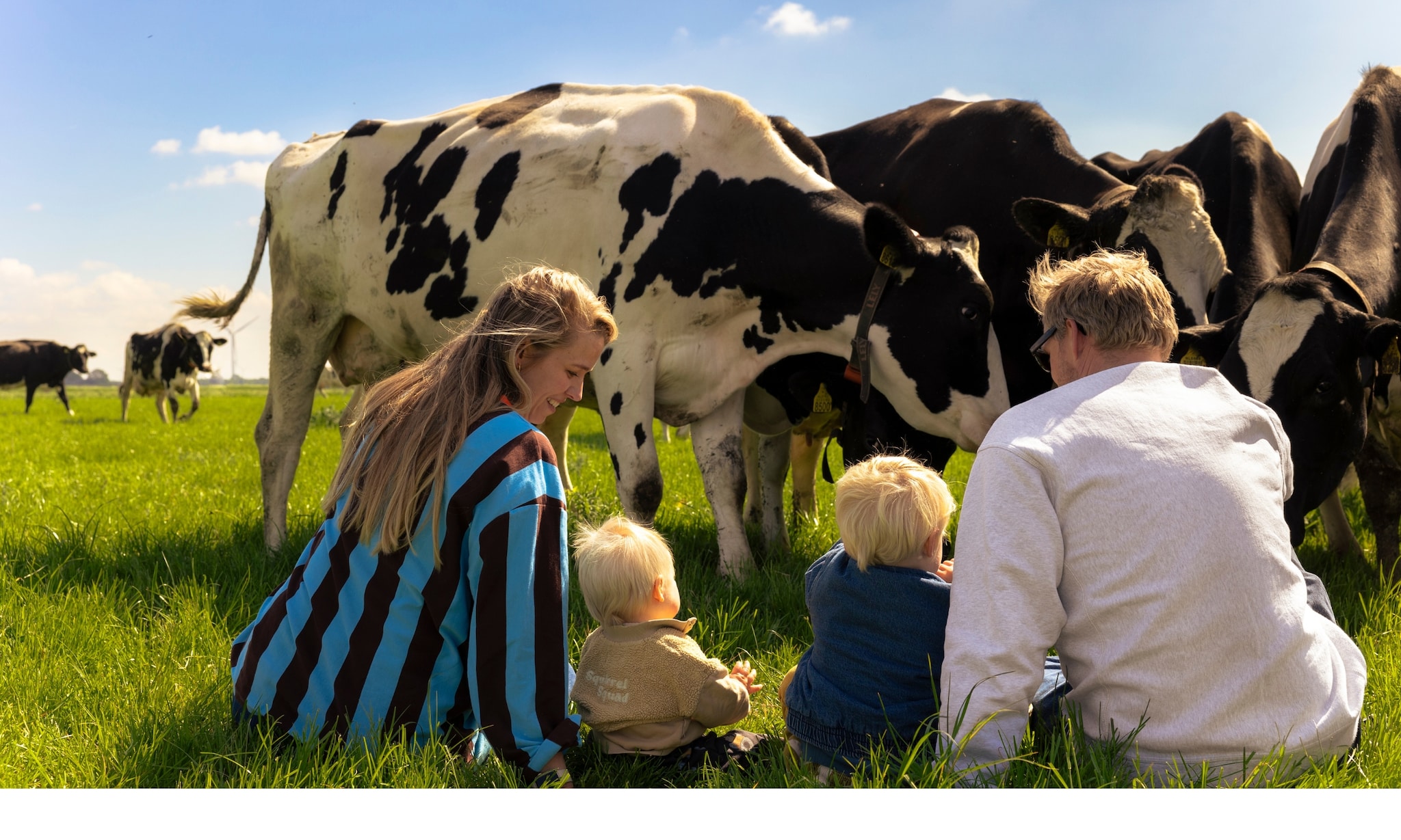 Leonie ter Veld in het weiland tussen de koeien met haar gezin