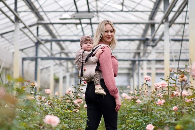 vrouw draagt peuter in draagzak van Pure Baby Love Pure Baby Love
