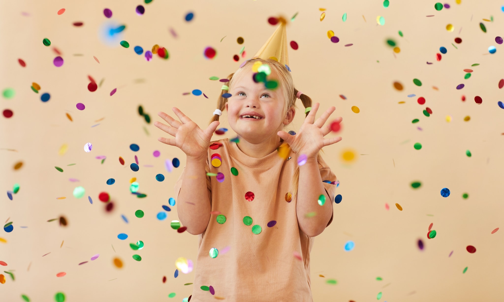 meisje draagt feestmuts en gooit met confetti