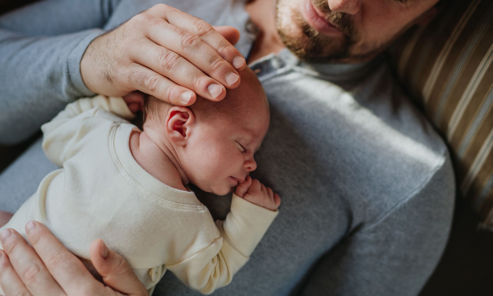 Vader met zijn baby op zijn borst.